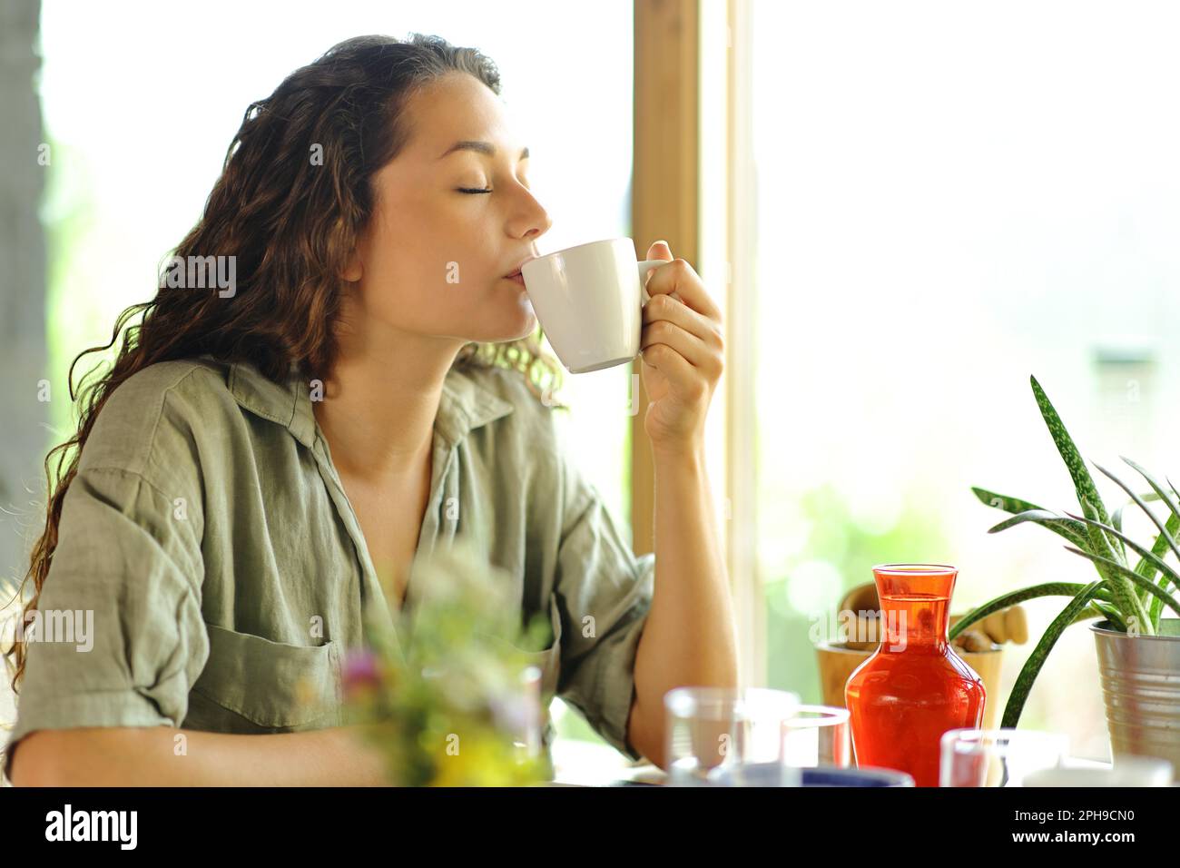 Donna che beve caffè seduto in un ristorante Foto Stock