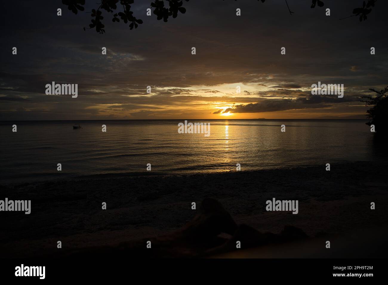 Pittoresco tramonto sulla spiaggia di Siquijor nelle Filippine, tutto il cielo si illumina di colore giallo dorato. Foto Stock