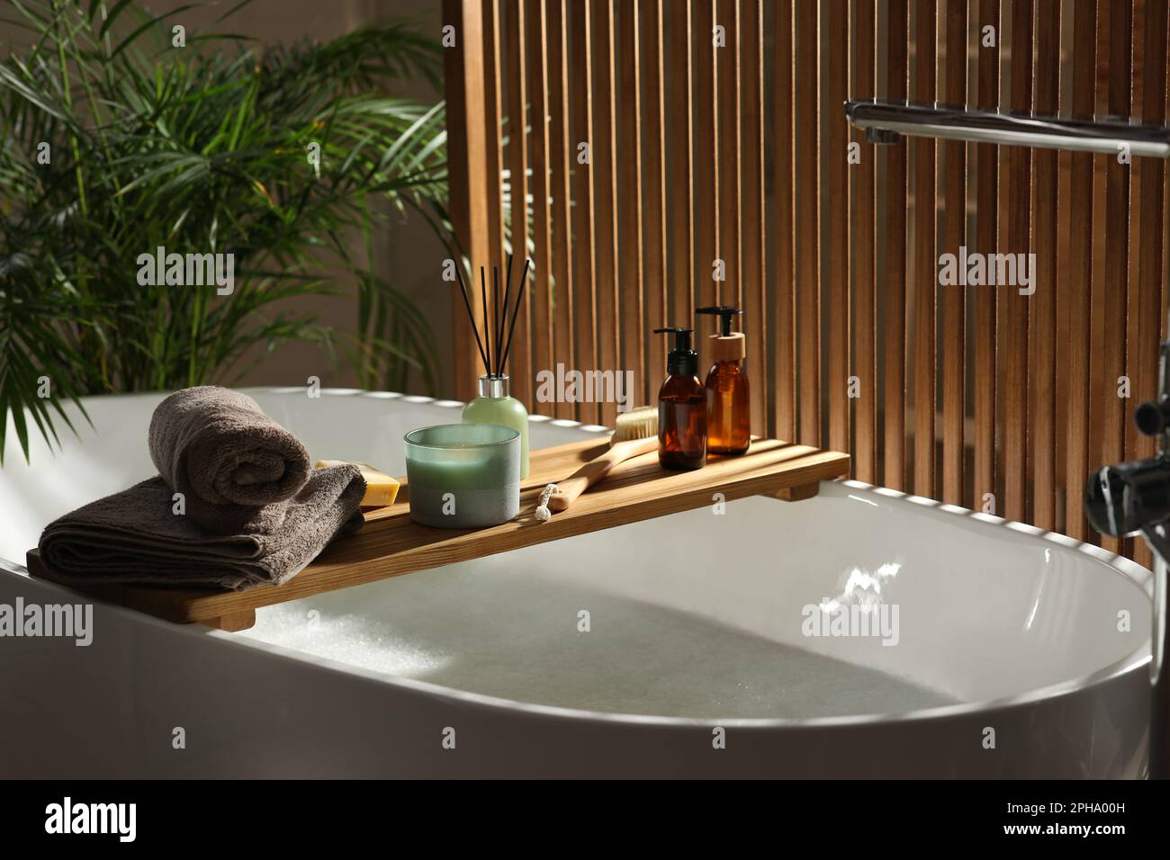 Vassoio da bagno in legno con candela, deodorante per ambienti e prodotti  da bagno in vasca interna Foto stock - Alamy