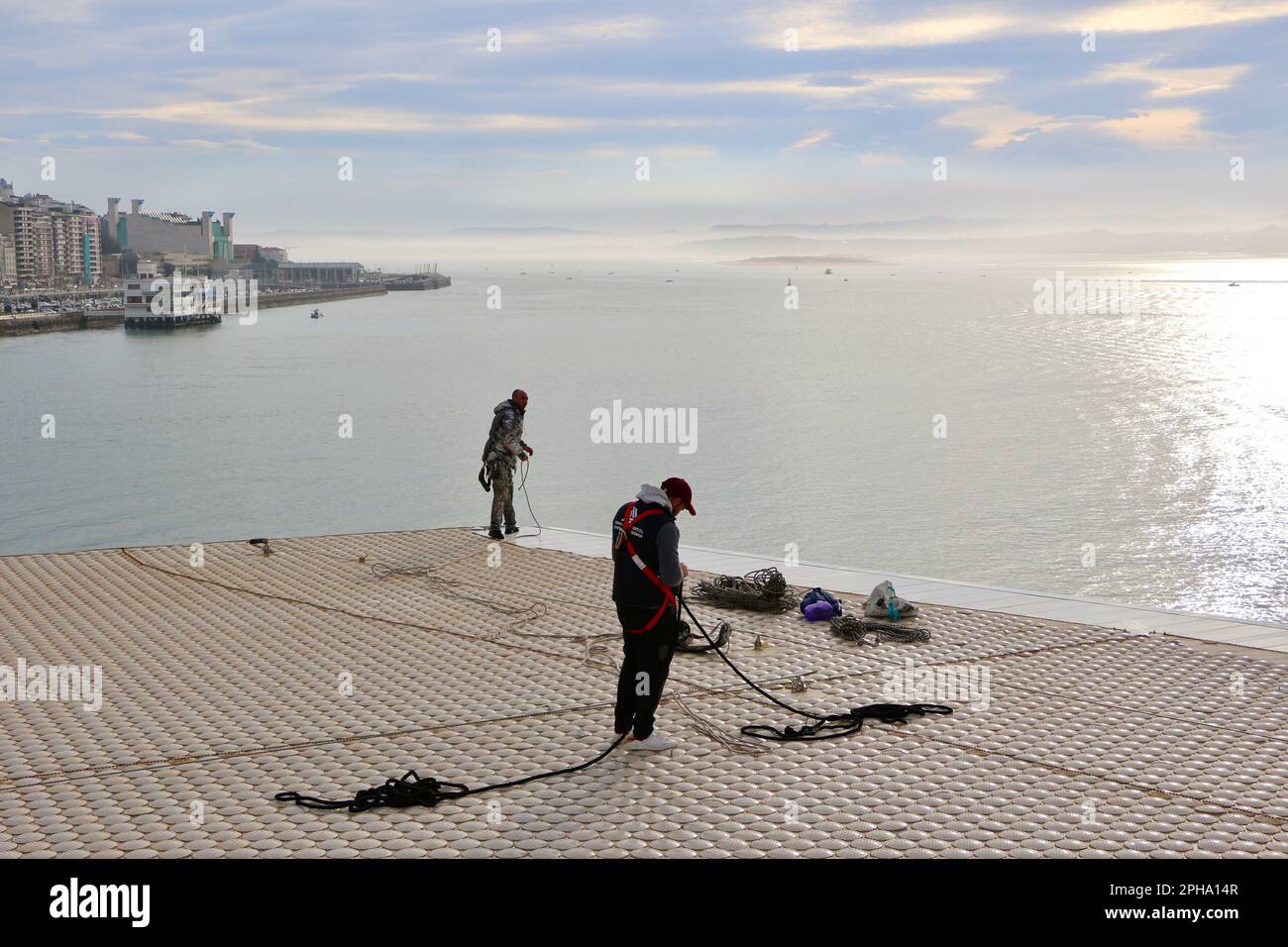 I lavoratori che accedono alla corda si preparano ad effettuare riparazioni sul tetto in ceramica al Botin Arts Centre Giardini Pereda Santander Cantabria Spagna Foto Stock