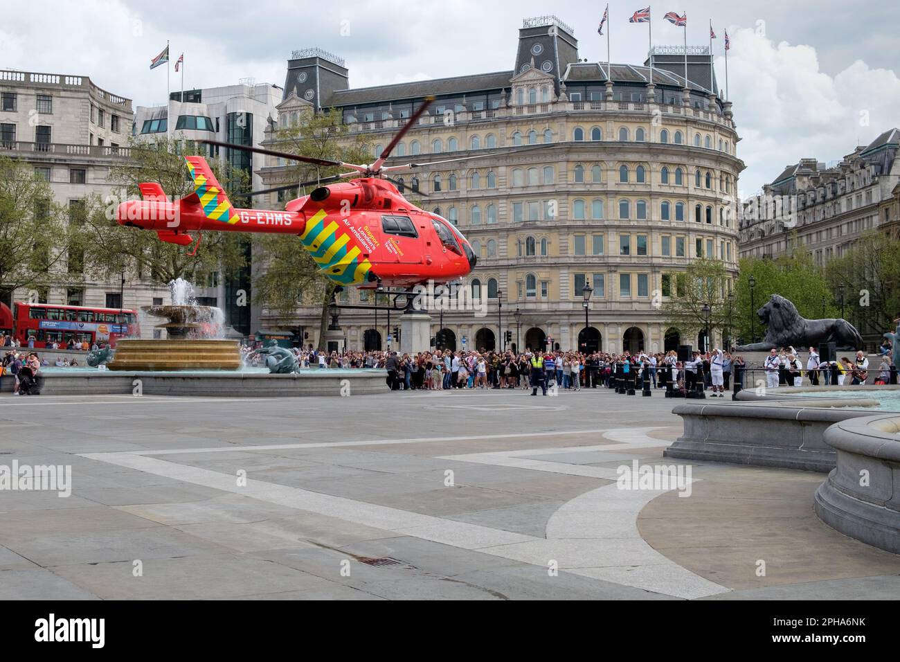 L'elicottero Air Ambulance di Londra atterra a Trafalgar Square, fornendo paramedici in caso di incidente stradale, come la folla guarda. Foto Stock