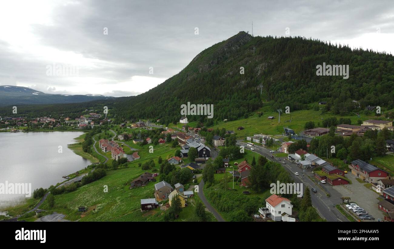 Una vista aerea di una pittoresca città, un lago e montagne boscose Foto Stock