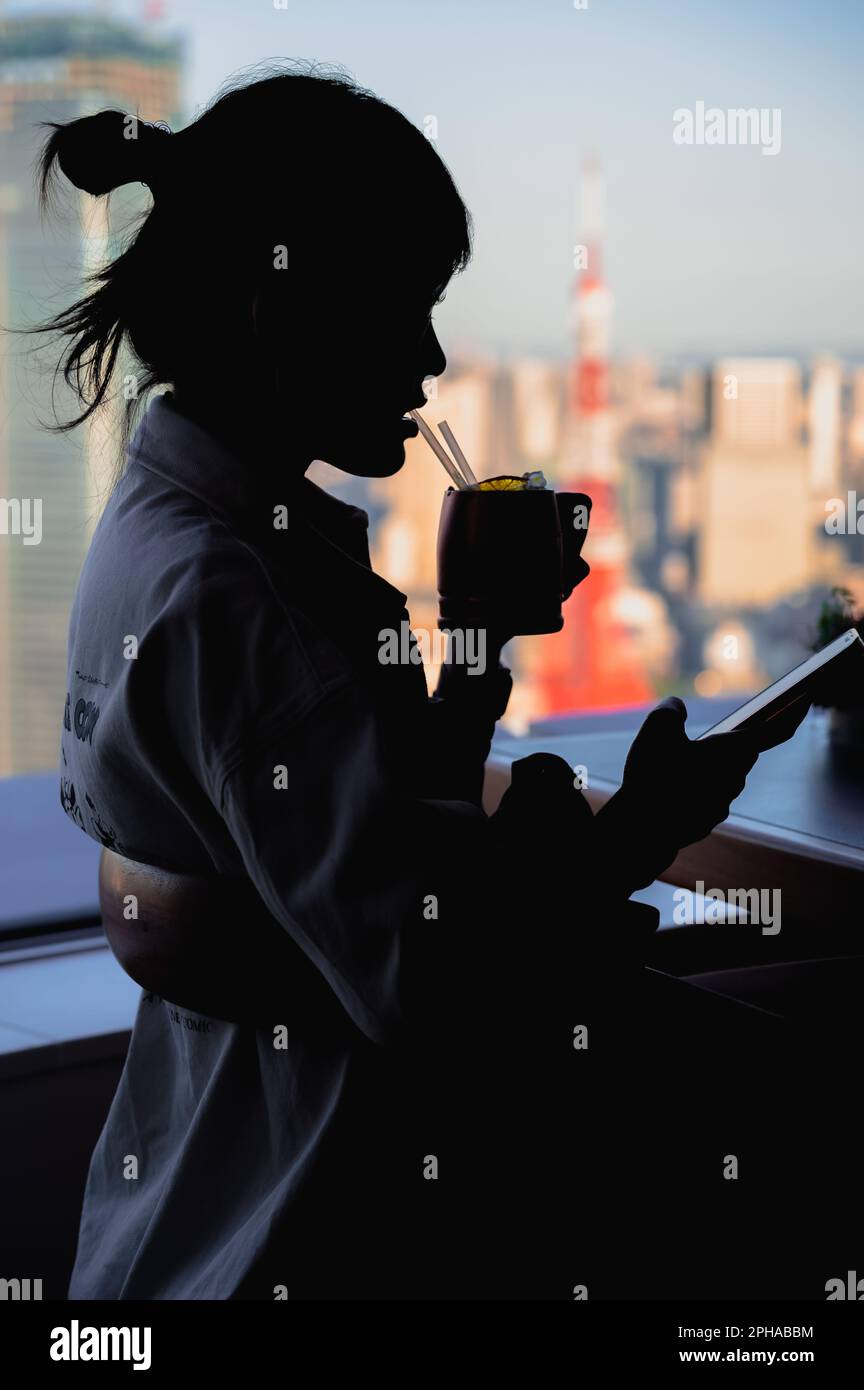 Silhouette, testa e spalle di una donna con vista sulla città della torre di Tokyo come sfondo Foto Stock