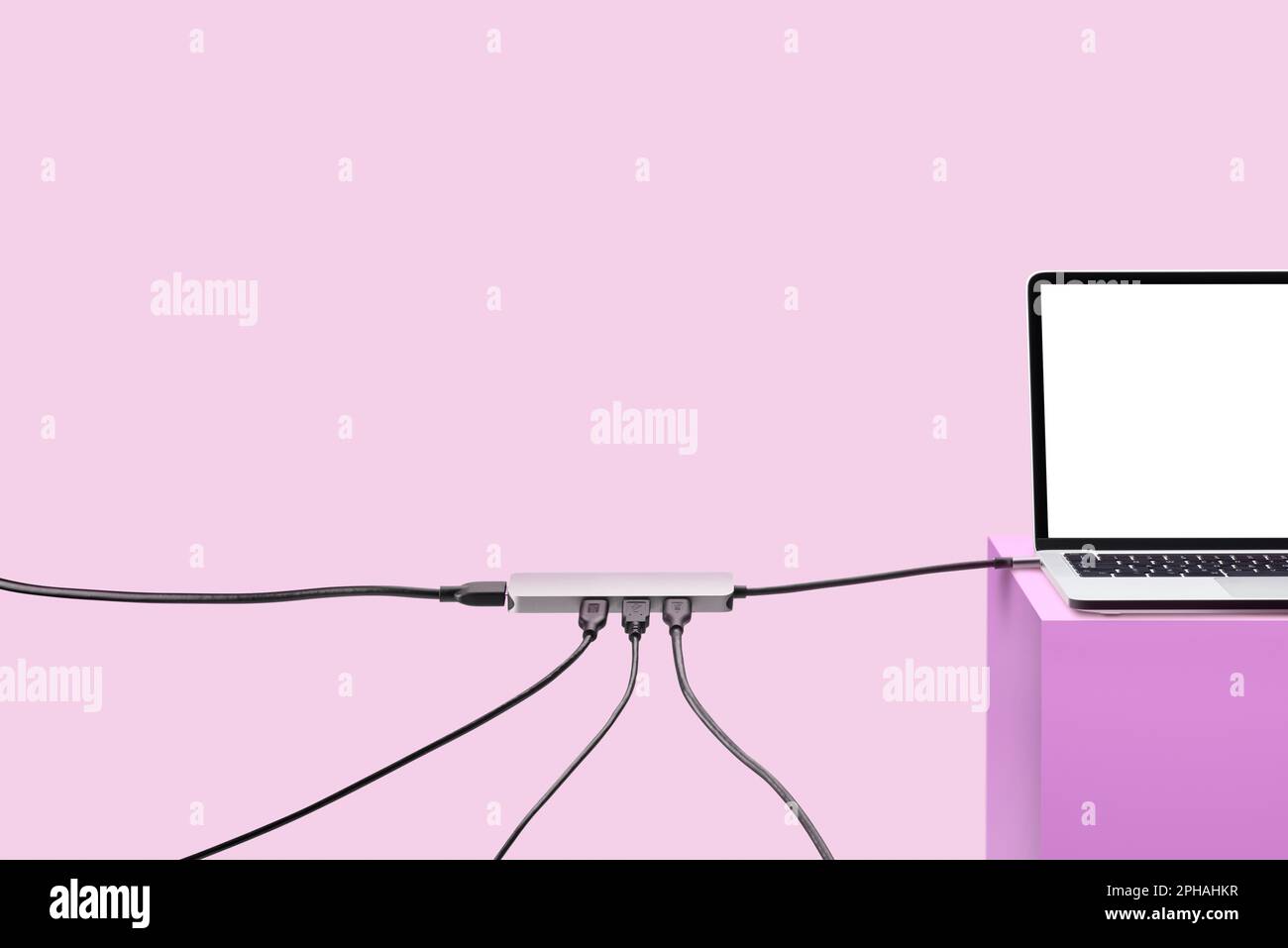 Computer portatile su piedistallo colorato con cavi. Sfondo rosa. Concetto di connessione. Foto Stock