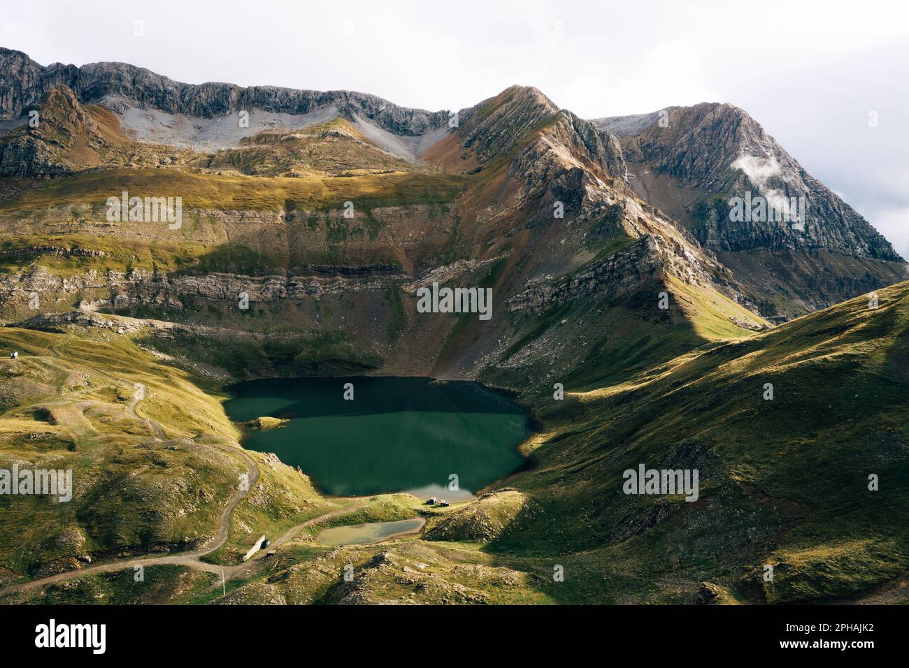 Un paesaggio sereno caratterizzato da un lago tranquillo circondato da colline lussureggianti e ondulate in una valle Foto Stock
