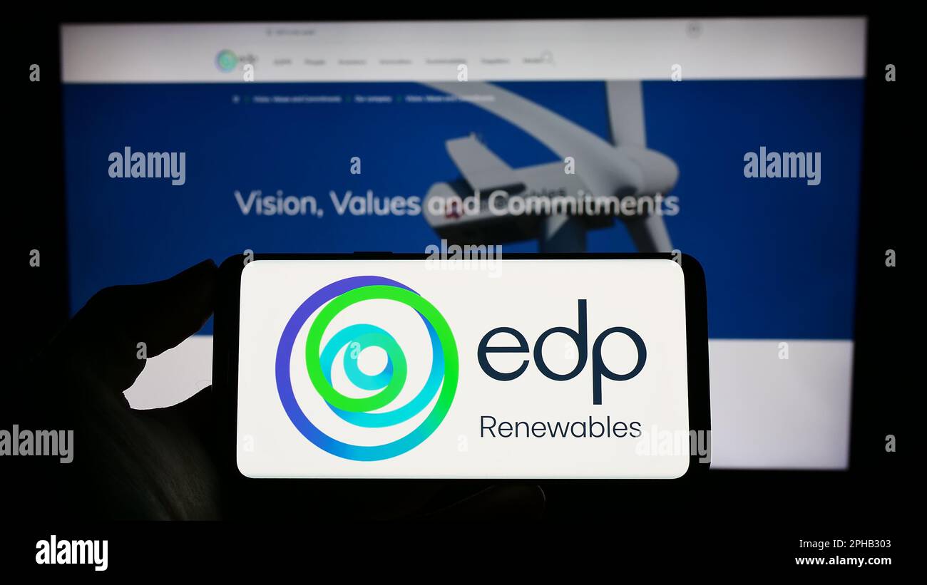 Persona che tiene il cellulare con il logo della società spagnola di energia EDP Renovaveis S.A. (EDPR) sullo schermo davanti alla pagina web. Messa a fuoco sul display del telefono. Foto Stock