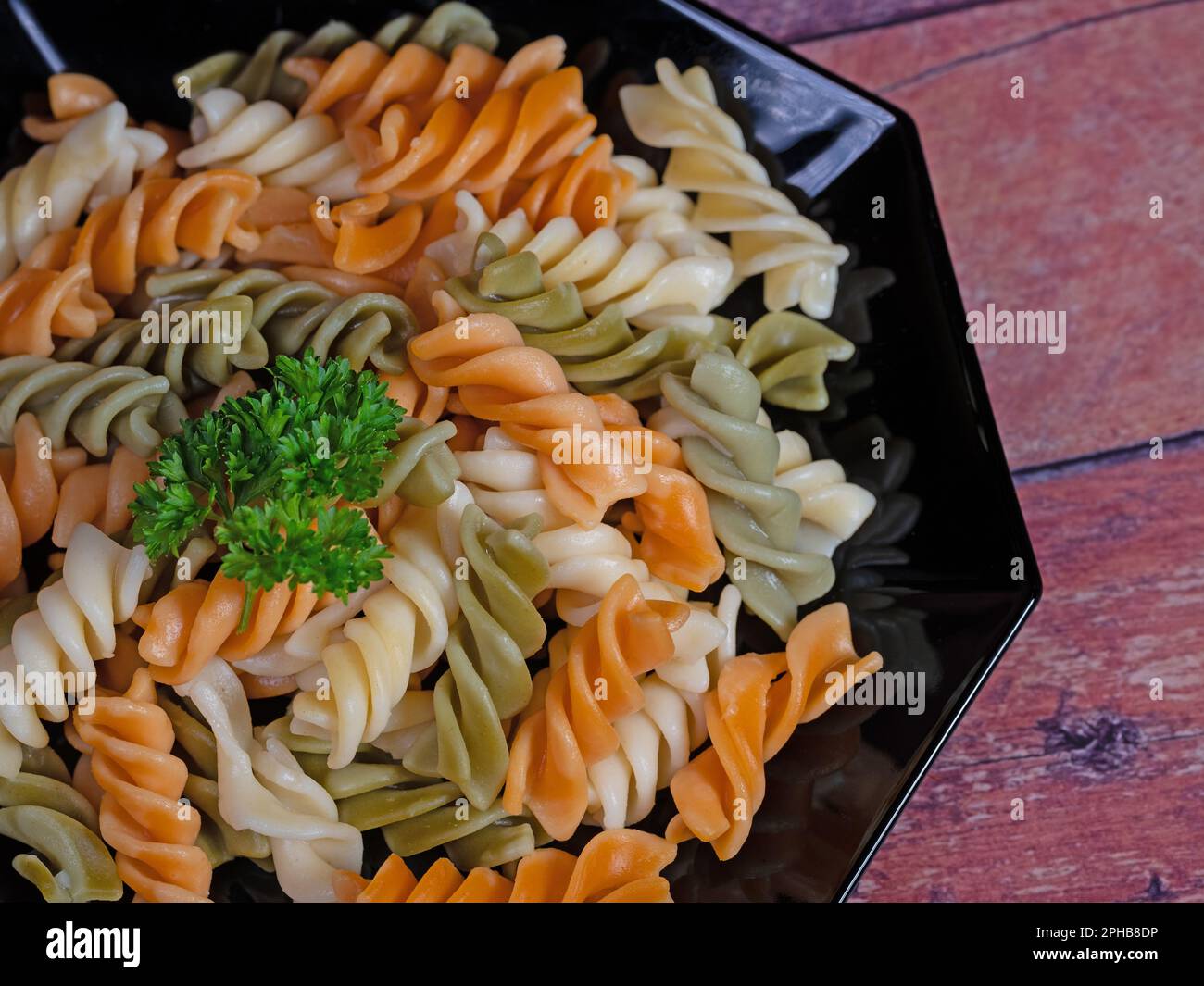 Pasta colorata a spirale su un piatto Foto Stock