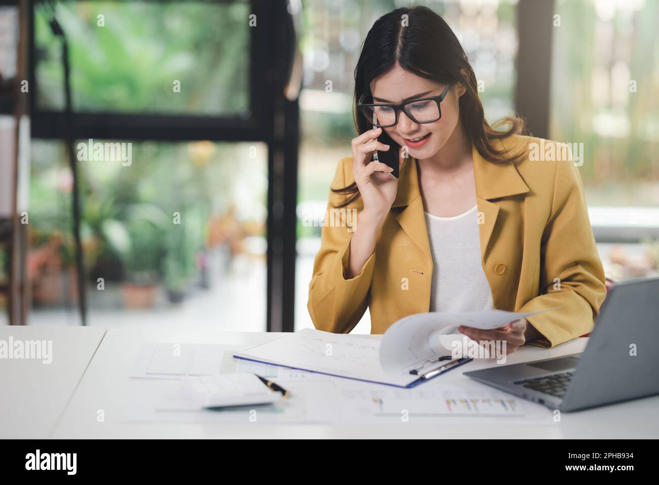 Concetto di business Office donna che lavora, Businesswoman utilizzando smartphone parlare con il suo cliente circa il piano di invesment e il controllo analisi documento AN Foto Stock
