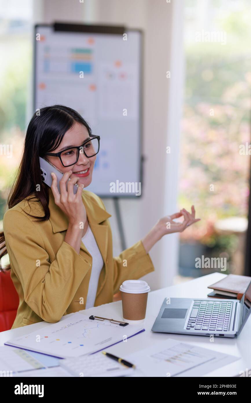 Concetto di business Office donna che lavora, Businesswoman utilizzando smartphone parlare con il suo cliente circa il piano di invesment e il controllo analisi documento AN Foto Stock