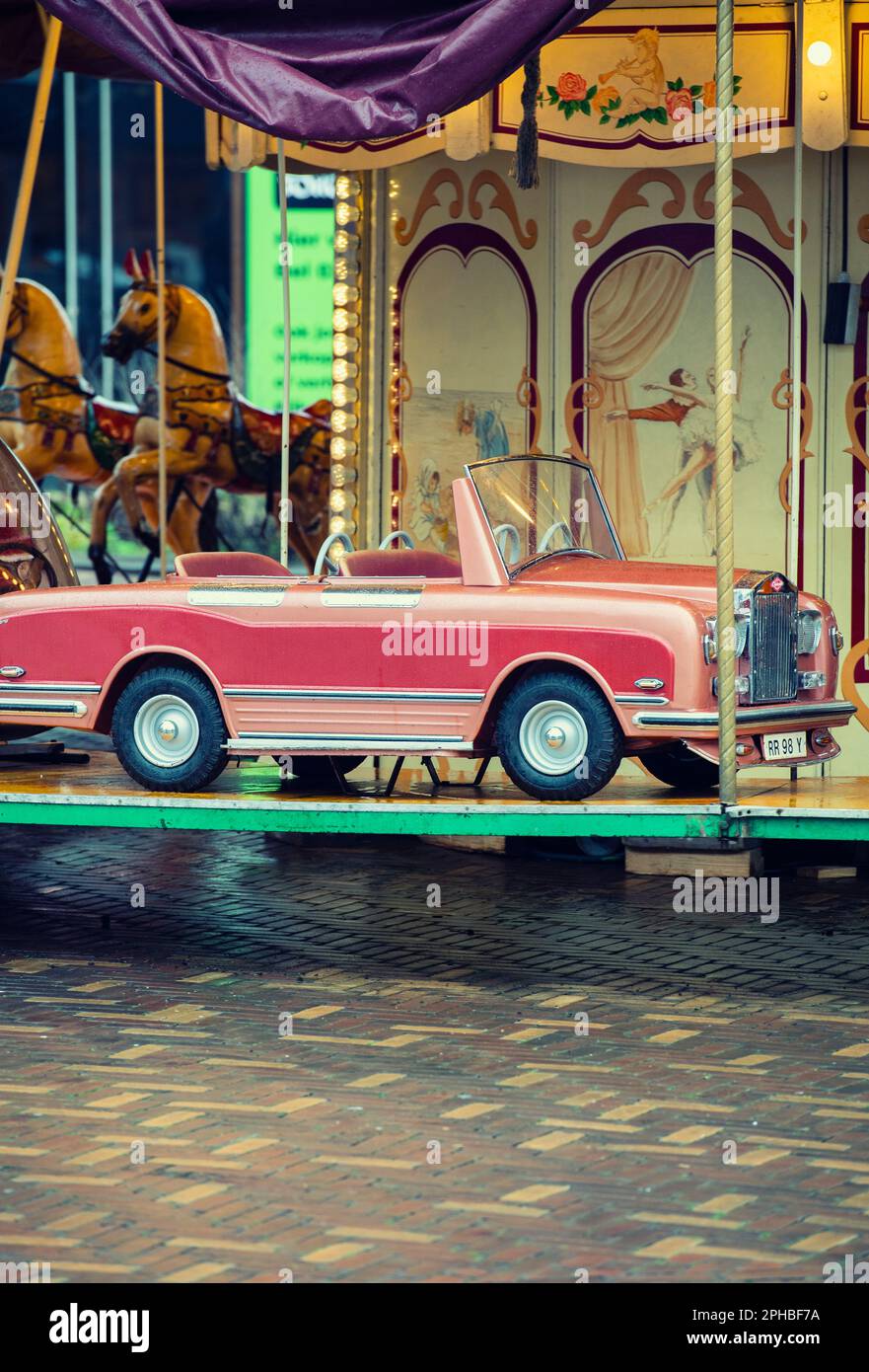 Auto rosa su una giostra per bambini Foto Stock