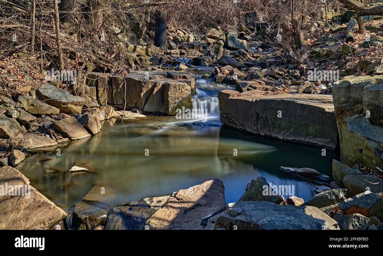 Una lunga esposizione di Wolf Creek, un ruscello che scorre con piccole cascate che si svuotano in una piscina di vetro. A Ridgefield, New Jersey, Stati Uniti. Foto Stock