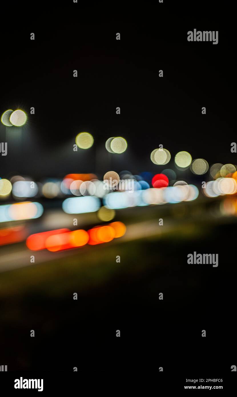 Illuminazione stradale e luci per auto sfocate di notte Foto Stock