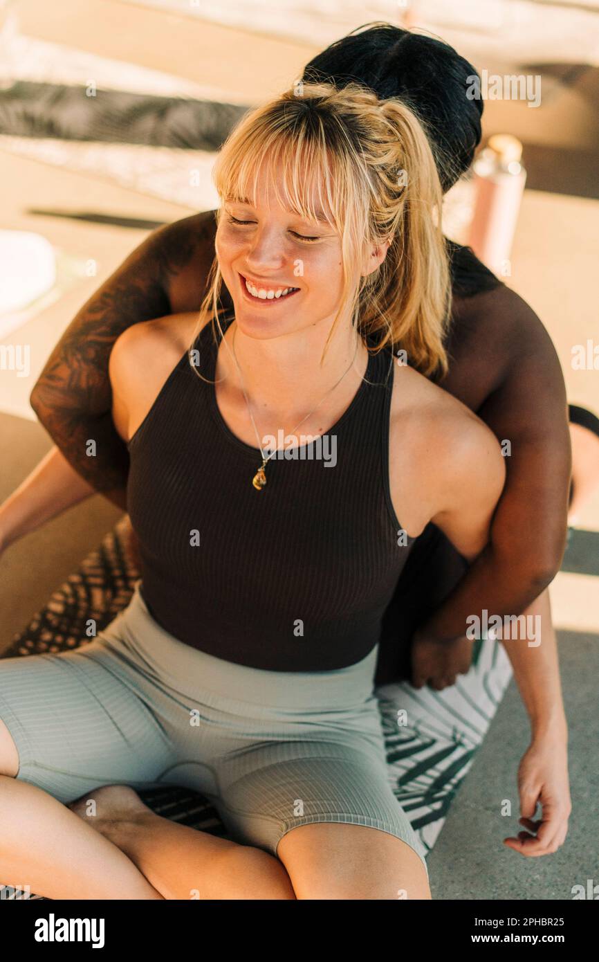 Donna felice che si esercita con l'amico femminile al centro di ritiro Foto Stock