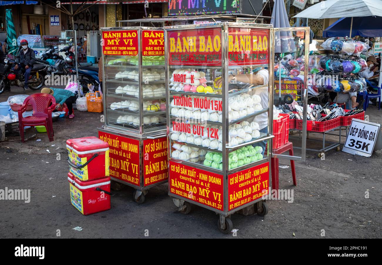 Armadietti di vetro riscaldati pieni del tradizionale vietnamita carne al vapore- e uovo-riempito di panino chiamato banh bao per la vendita al mercato centrale di PLEIKU in Foto Stock