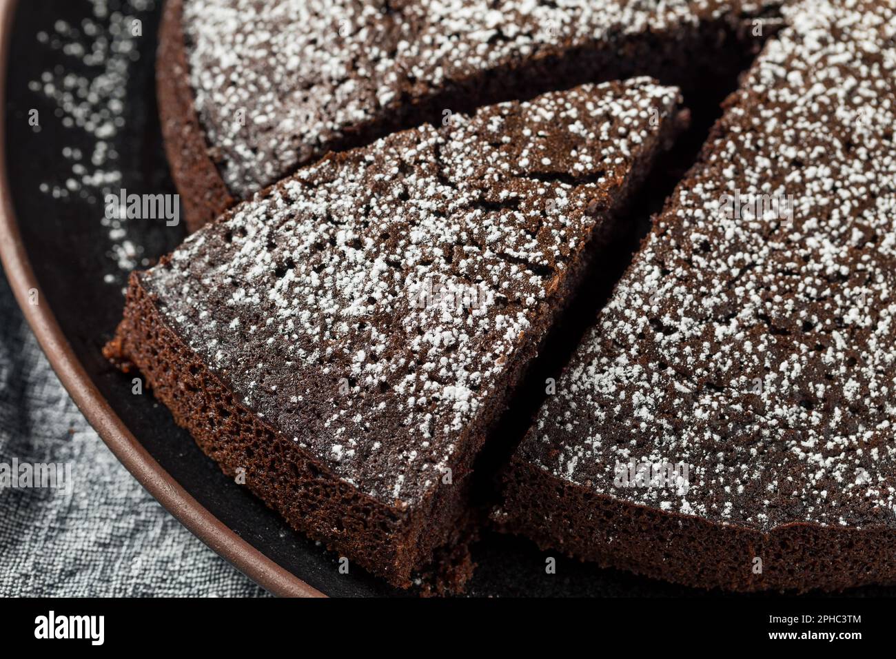 Torta all'olio di oliva al cioccolato al forno con zucchero in polvere Foto Stock