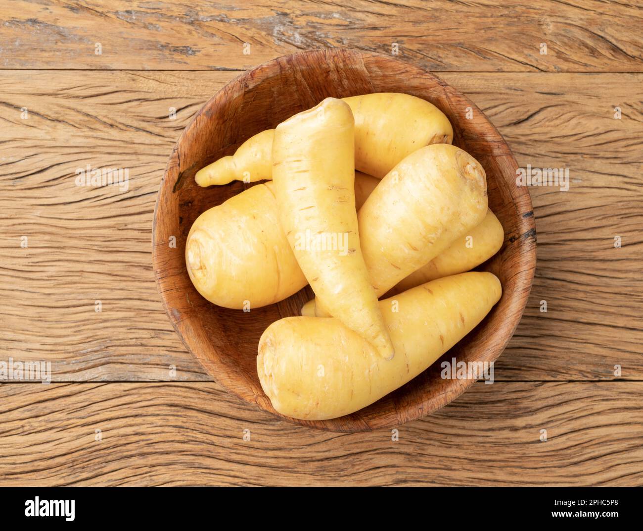 Mandiochinha crudo o arracacha in una ciotola su tavola di legno. Foto Stock