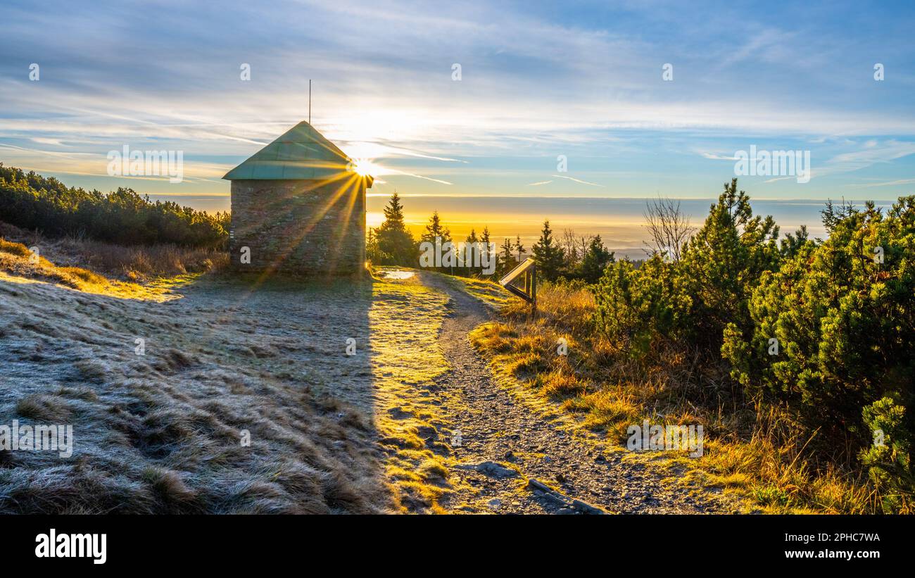 Una mattinata gelida e soleggiata con raggi di sole che splende attraverso un rifugio turistico in pietra a Jeleni studanka, sulle montagne di Hruby Jesenik, Repubblica Ceca Foto Stock