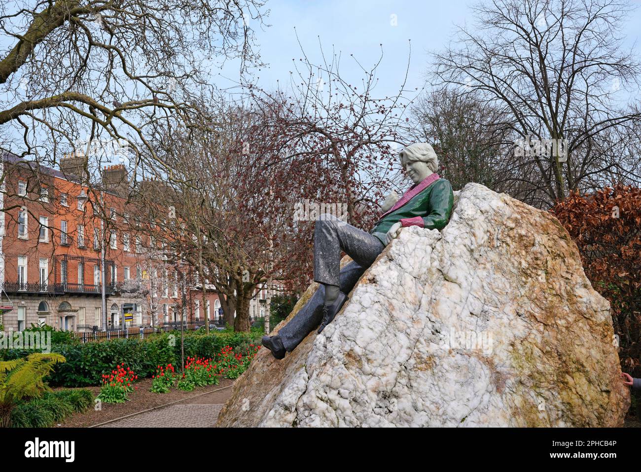 Statua commemorativa di Oscar Wilde di Danny Osborne, sdraiato su una roccia a Merrion Square Park a Dublino, guardando verso la casa dove è nato Foto Stock