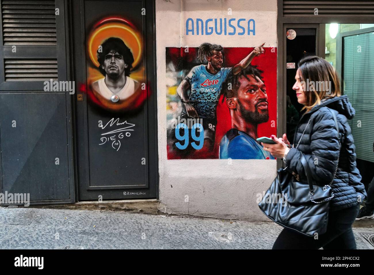 Una donna cammina davanti ad un murale, creato dall'artista Juan Pablo Gimenez, dedicato al giocatore Andre Zambo Anguissa in Via Trinita degli Spagnoli in Foto Stock