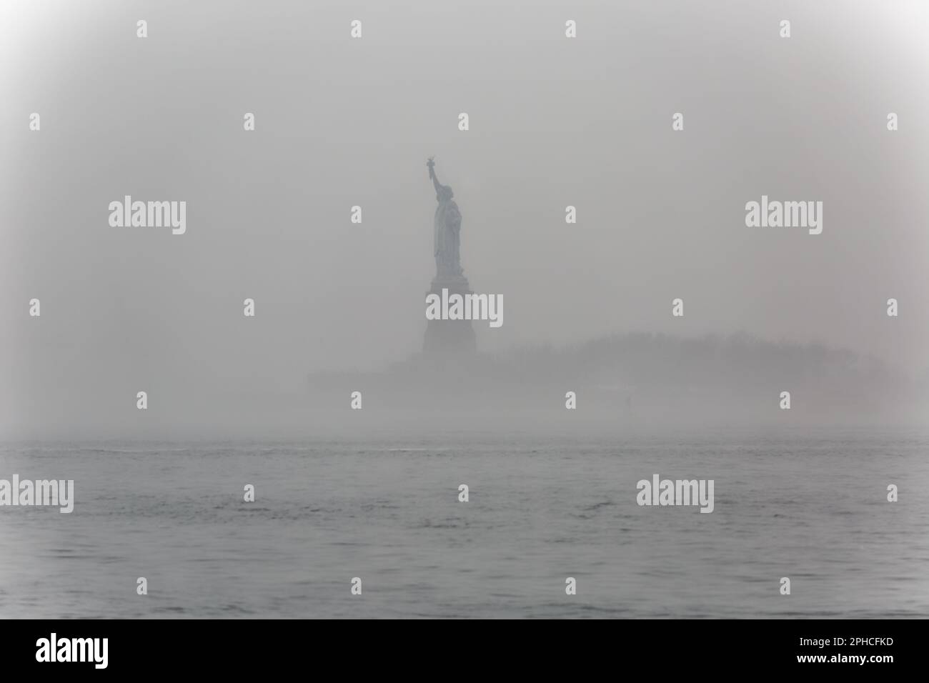 Statua della libertà, in una nebbia mattina di febbraio, fotografata dal Battery Park di Manhattan. Foto Stock