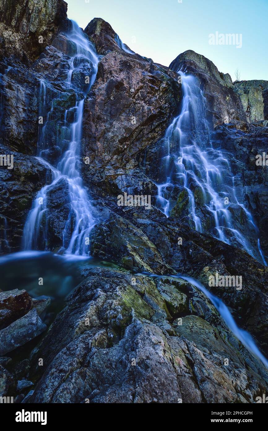 Bellissima cascata con effetto acqua sfocata. Foto scattata nella Valle dei cinque stagni sui Monti Tatra polacchi. Foto a lunga esposizione. Foto Stock