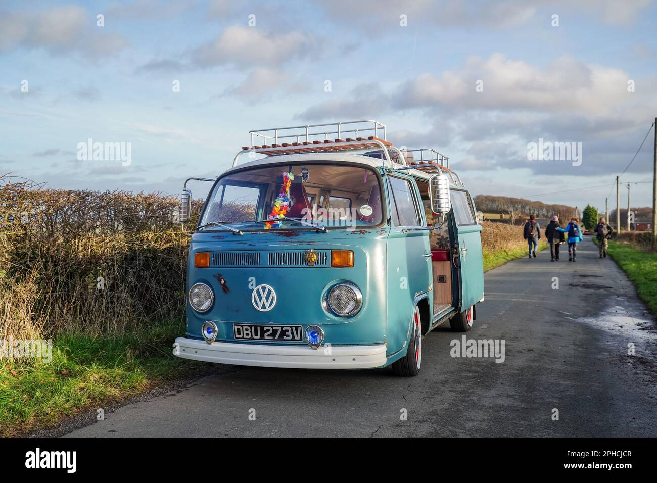 Il camper Volkswagen 'Bay Window' parcheggiato su una corsia di campagna vicino a Hoober, South Yorkshire, con un gruppo di escursionisti che si stendono lungo la corsia dietro Foto Stock