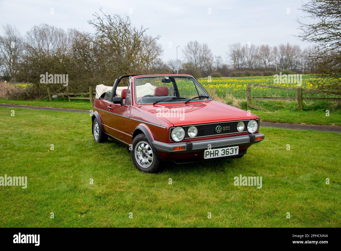 Volkswagen Golf Cabriolet parcheggiato in un prato con campi dietro in primavera Foto Stock