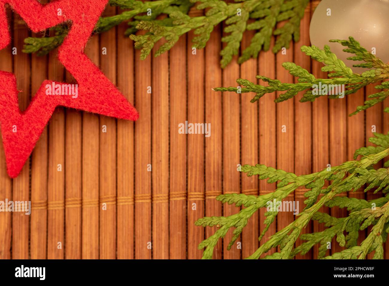 decorazione di natale su sfondo in legno con palla albero di natale, ramo verde e stella rossa. Disposizione piatta, vista dall'alto, spazio di copia Foto Stock