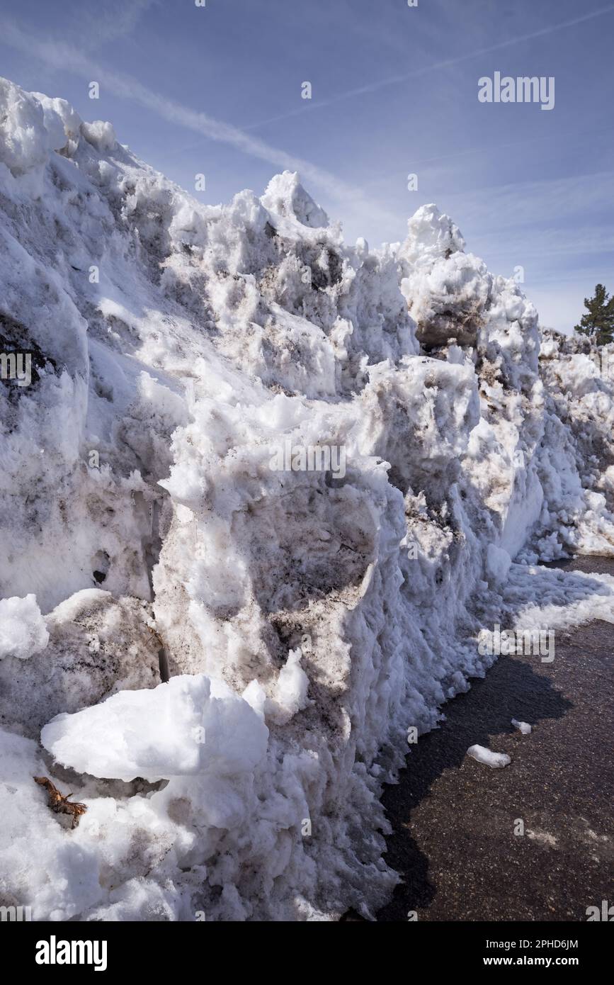 fusione del cumulo di neve sporco lungo una strada arata Foto Stock