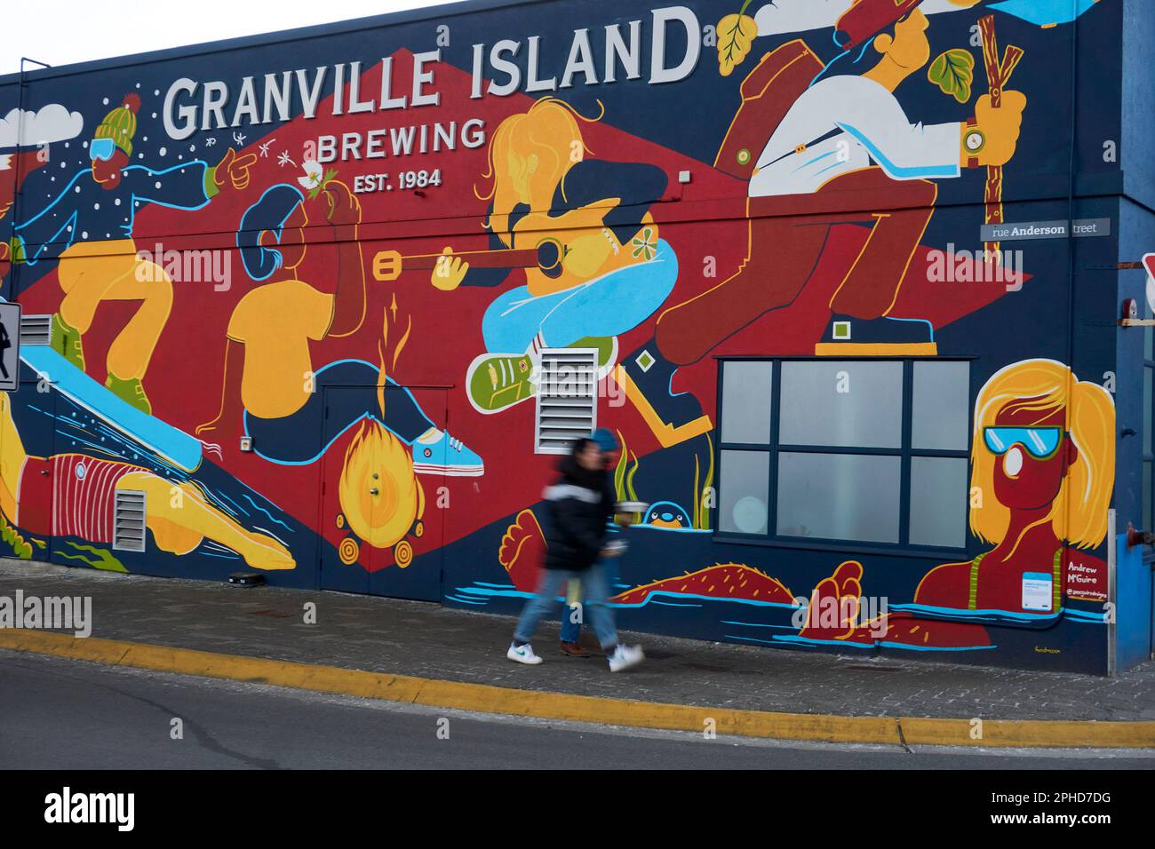 Due persone passeggiando davanti ad un murale nell'edificio della Granvile Island Brewing Company a Granville Island, Vancouver, BC, Canada Foto Stock