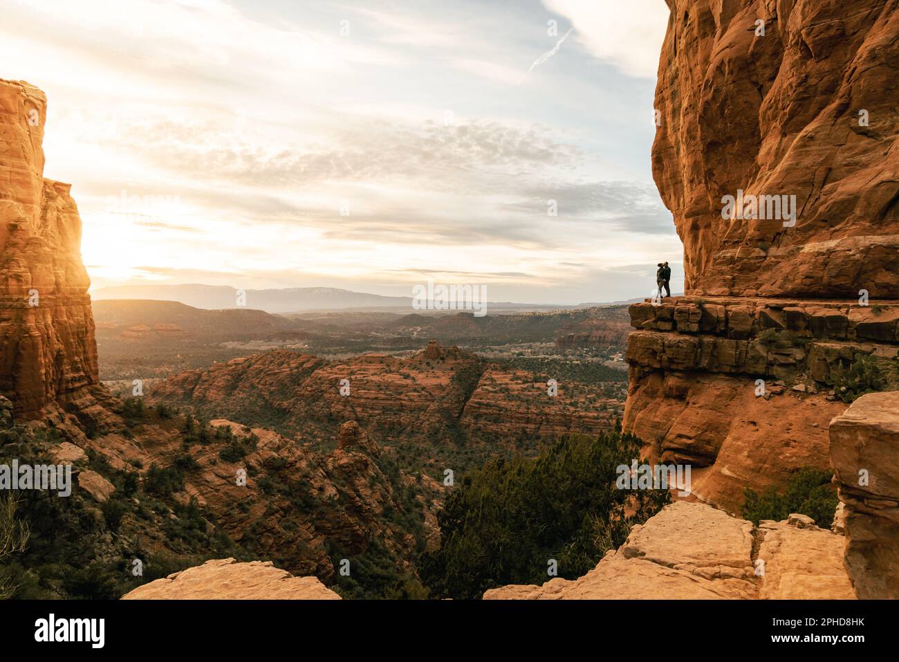 Una giovane coppia eterosessuale si bacia al punto panoramico durante il suggestivo tramonto dalla Cathedral Rock di Sedona. Foto Stock