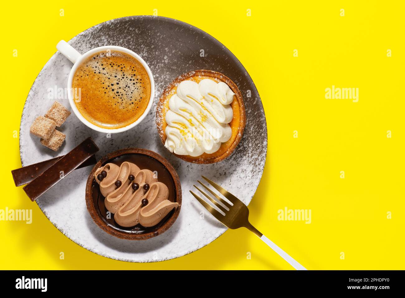 Caffè mattutino, torta deliziosa e cioccolato. Copia spazio.sfondo giallo Foto Stock