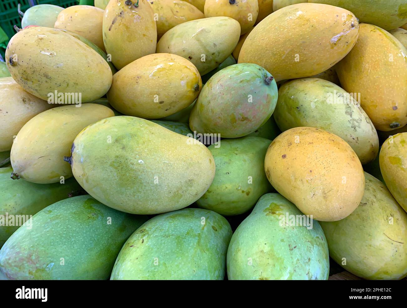 Un mucchio di freschi e colorati mango tropicali nel supermercato Foto Stock