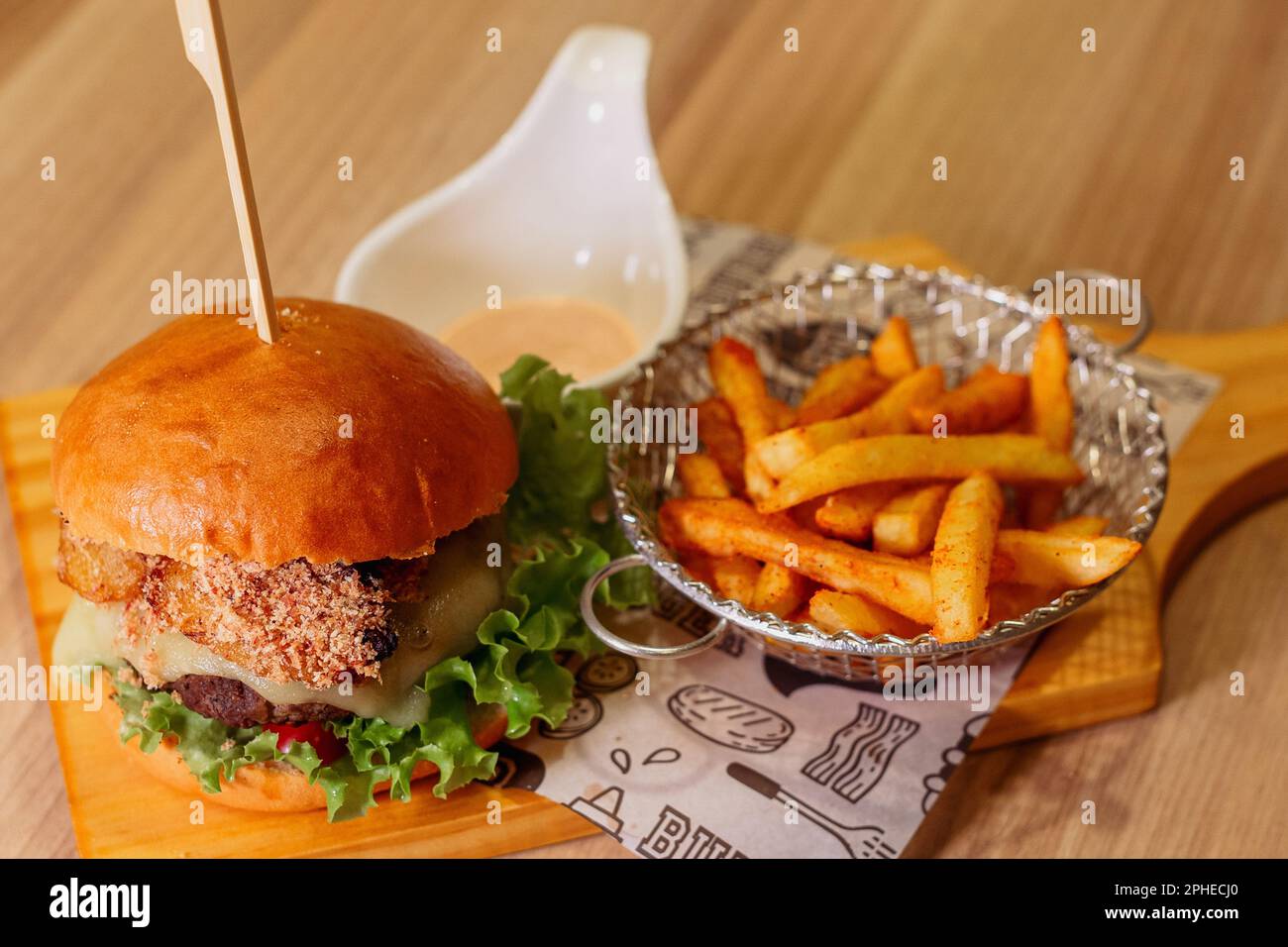 Un delizioso hamburger e patatine fritte servite su un tagliere, pronto per essere gustato Foto Stock