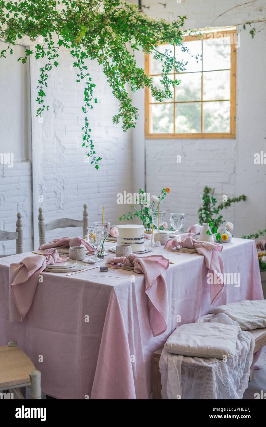 Elegante tavolo servito con piatti e fiori vicino torta yummy su