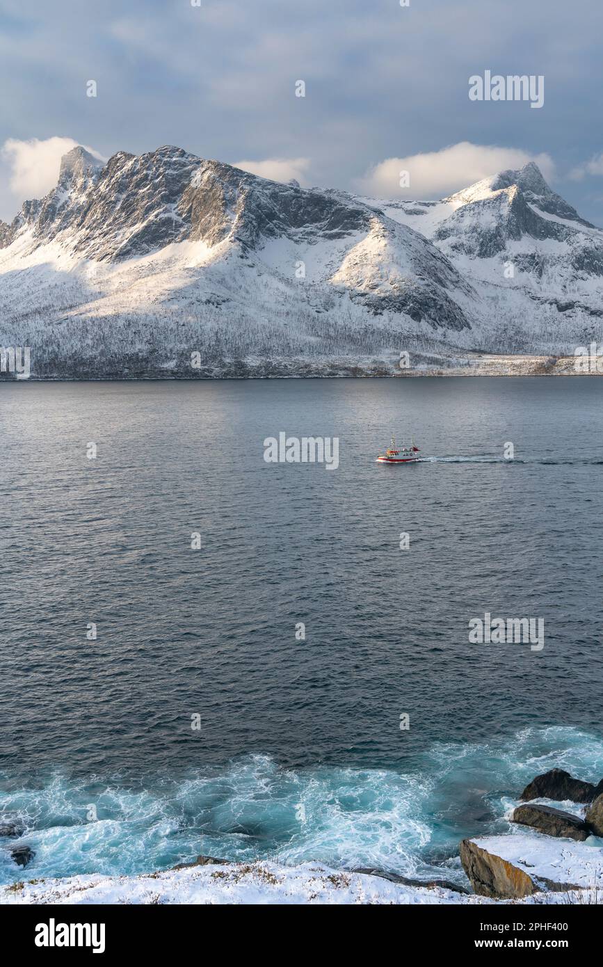 Schiff im Øyfjorden, mit den schneebedeckten Bergen von Senja, genannt Segla, Kongan und Skulvan im Hintergrund. Norvegese Foto Stock