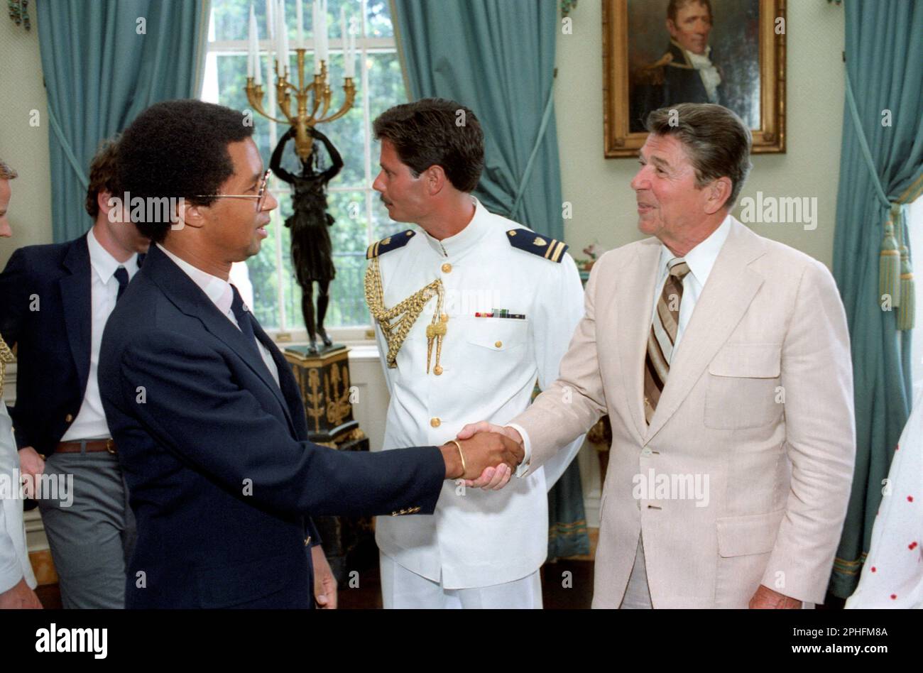 Il presidente Ronald Reagan stringe le mani con il campione di tennis Arthur Ashe (1943-1993) in un evento della White House Blue Room della squadra di tennis statunitense Davis Cup, Washington, DC, 7/19/1982. (Foto di White House Press Office/ Foto Stock
