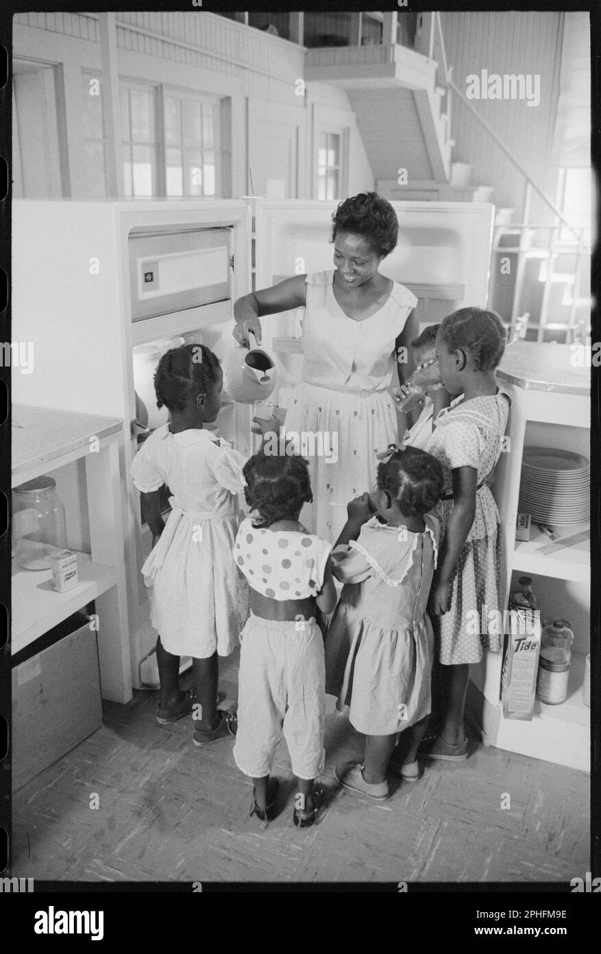 Donna al frigorifero che tiene una caraffa mentre versa fuori le bevande per i bambini, Little Rock, AR, 8/20/1959. (Foto di John T Bledsoe/US News & World Report Magazine Photograph Collection Foto Stock