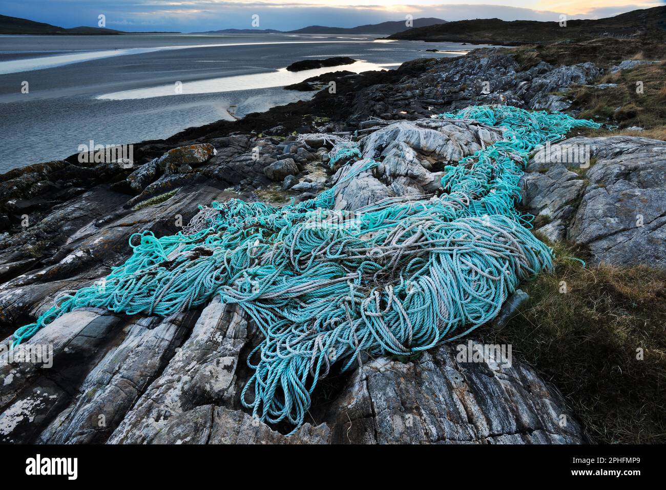 Inquinamento marino di plastica con corda di plastica scartata e rete di pesca commerciale lavato su riva a Luskentyre, Harris sud-occidentale. Foto Stock