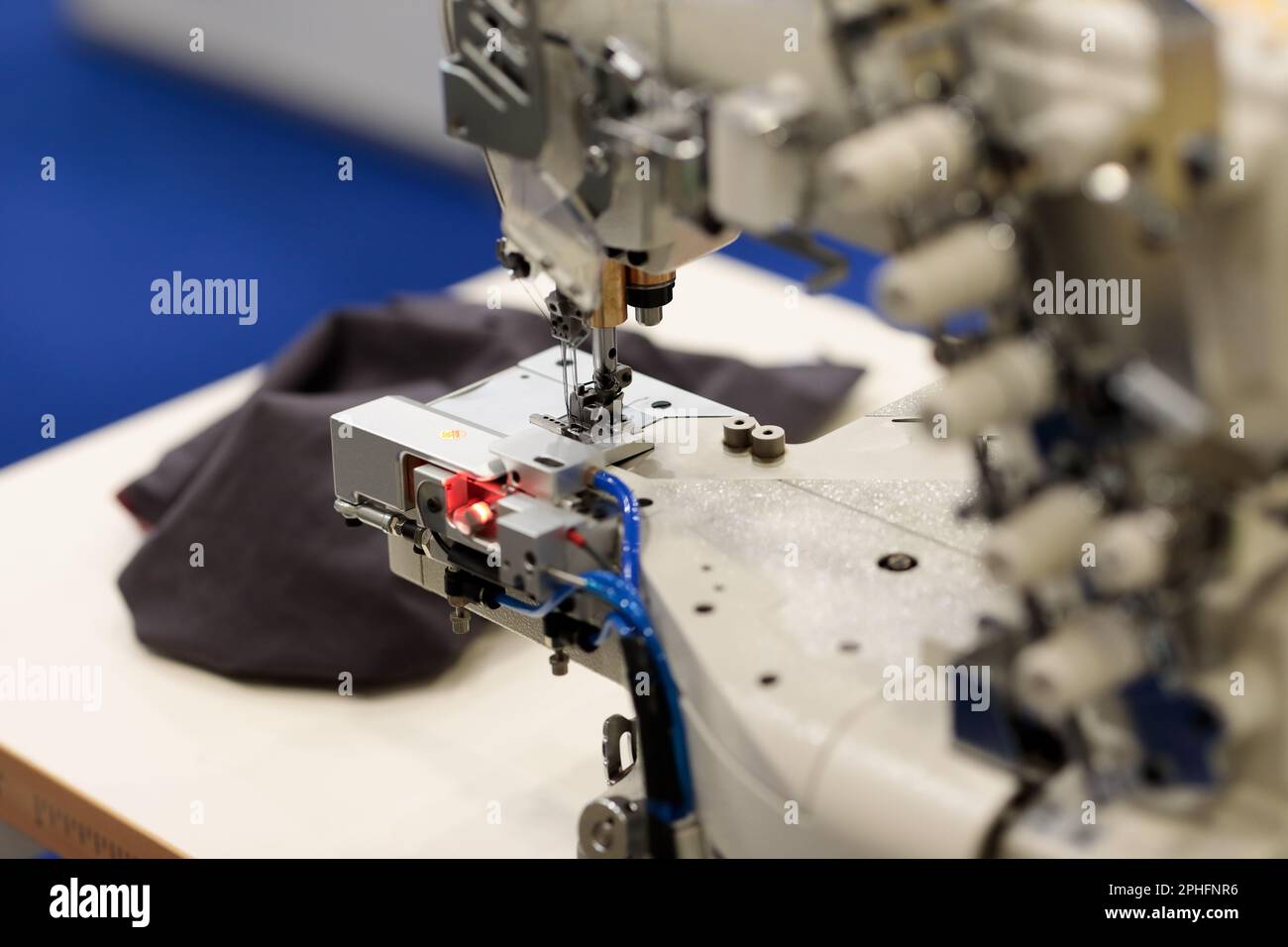 Primo piano della macchina per cucire industriale con cuciture. Messa a fuoco selettiva. Foto Stock