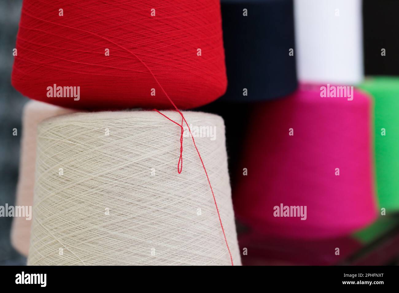 Coni colorati in filato di cotone per l'industria tessile primo piano. Messa a fuoco selettiva. Foto Stock