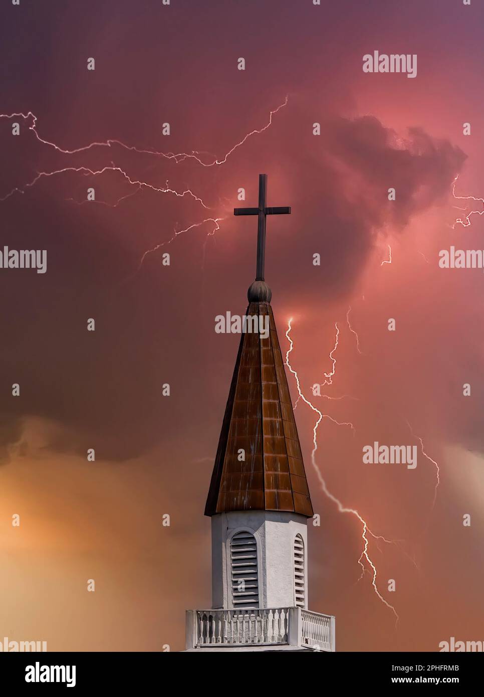 Campanile della chiesa con croce in cima contro un cielo scuro tempestoso Foto Stock