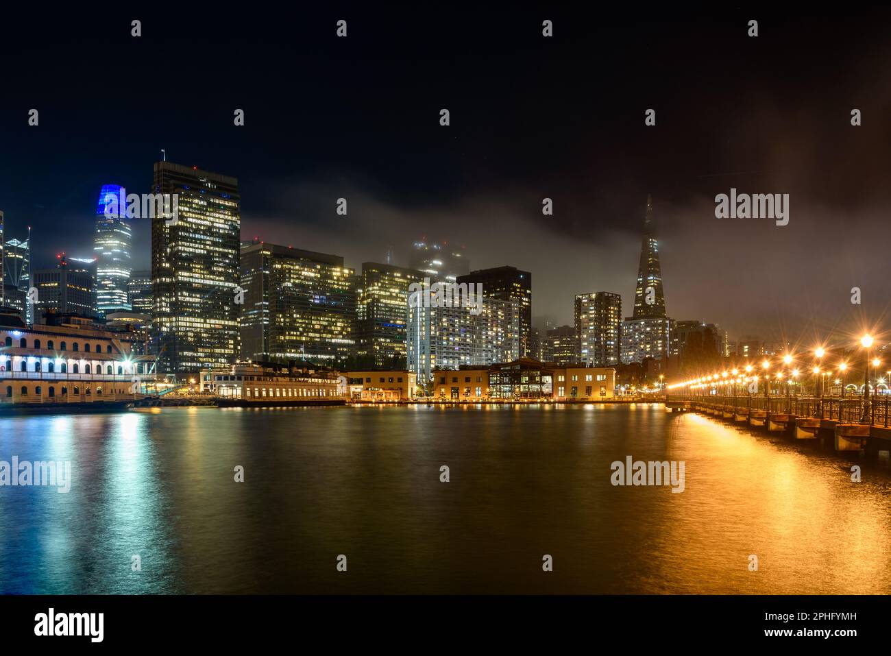 Skyline del centro di San Francisco parzialmente coperto di nebbia di notte Foto Stock