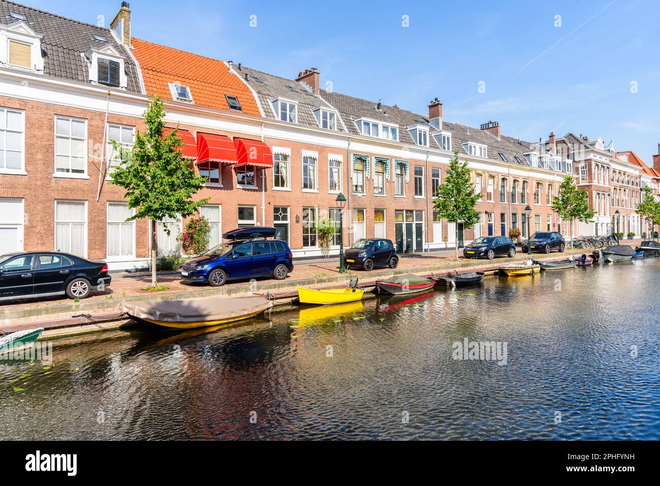 Case a file di mattoni lungo un canale in una giornata di sole estate Foto Stock