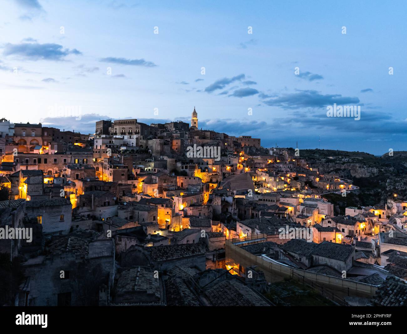 veduta aerea del centro storico della città di matera mentre il sole tramonta e le luci delle case storiche si accendono, basilicata, italia, tramonto, Foto Stock