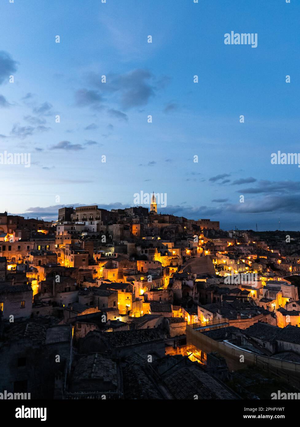 veduta aerea del centro storico della città di matera mentre il sole tramonta e le luci delle case storiche si accendono, basilicata, italia, tramonto, Foto Stock