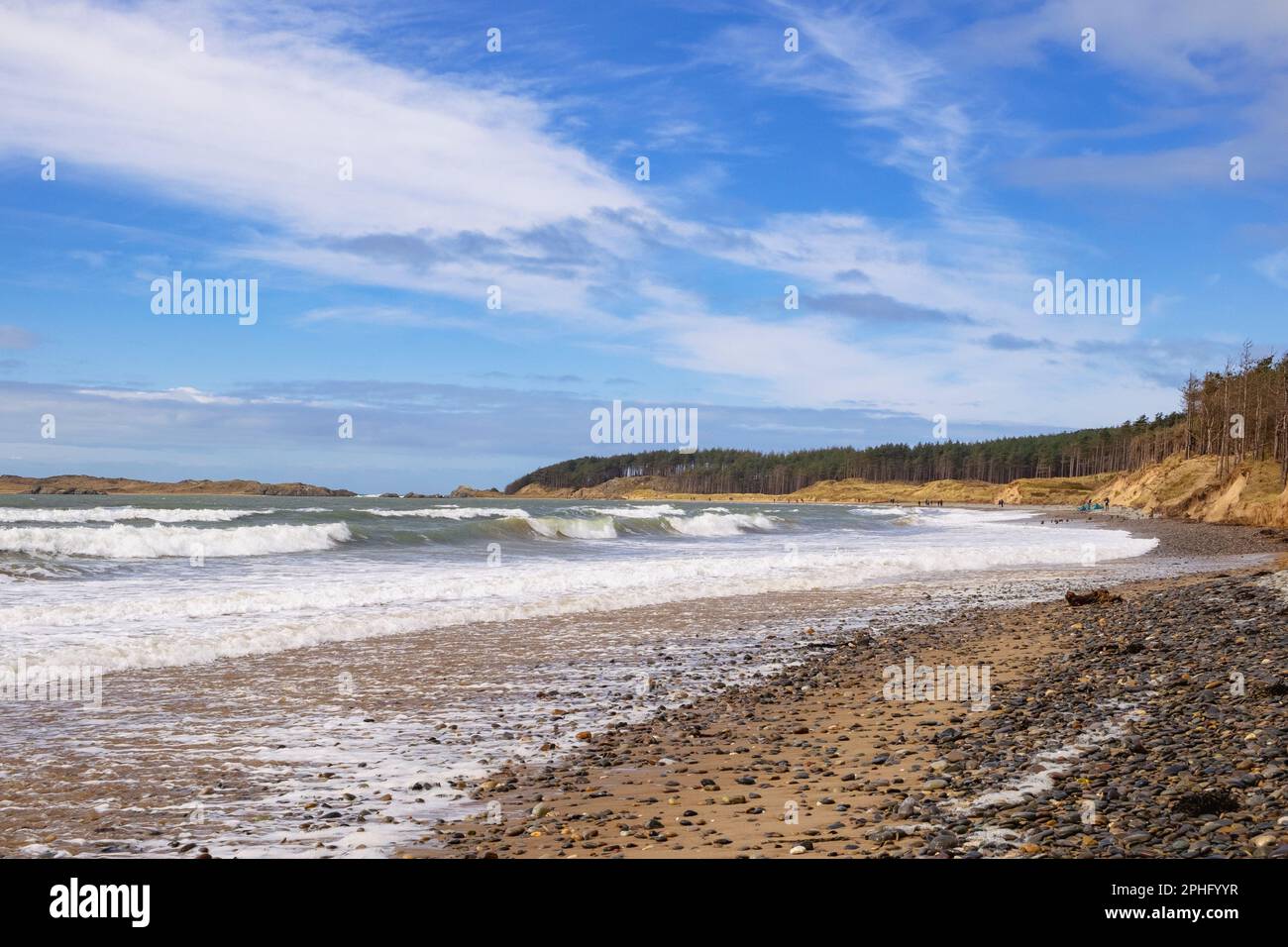 Le onde si dirigono verso la spiaggia di Newborough, con l'alta marea che guarda verso l'isola di Llanddwyn. Newborough, Isola di Anglesey, Galles, Regno Unito, Gran Bretagna, Europa Foto Stock