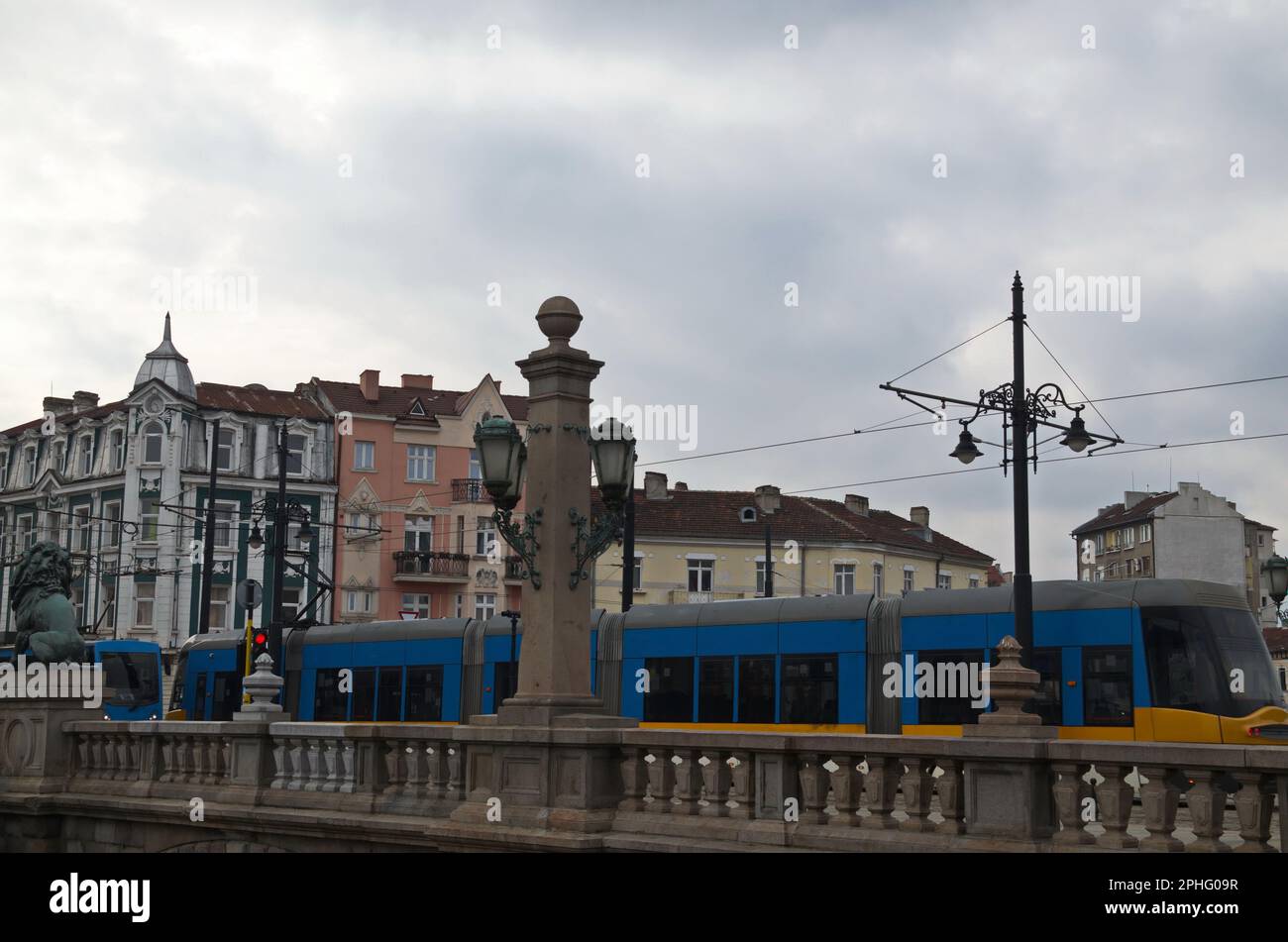 Tram che passa sopra il Ponte del Leone sul Fiume Vladaya dal 1889 con sculture di leoni, antichi edifici, incrocio e semafori, Sofia, Bulgaria Foto Stock