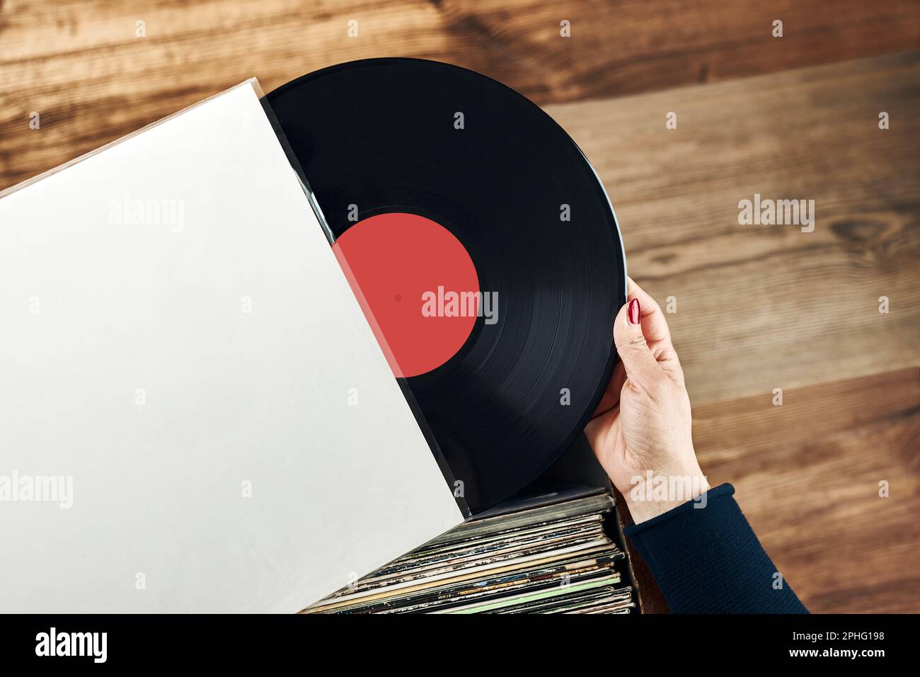 Riproduzione di dischi in vinile. Ascoltare musica dal lettore di dischi in vinile. Stile musicale retrò e vintage. Donna che detiene un album LP analogico. Pila di vecchio Foto Stock