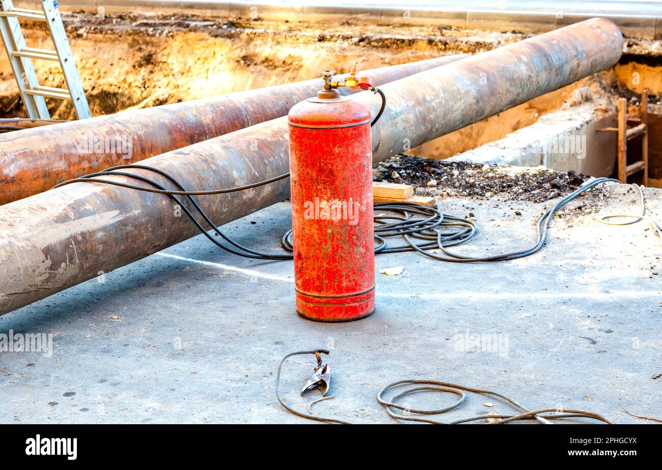 Cilindro in acetilene rosso con sensori di pressione. Attrezzatura per il taglio a gas di metalli. Attrezzatura per saldatura a gas per il taglio di metalli in cantiere Foto Stock